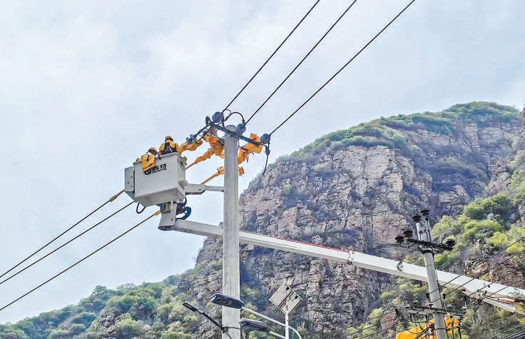 國網北京平谷供電公司在黃松峪鄉災後提升工程現場對10千伏線路開展架設導線工作。