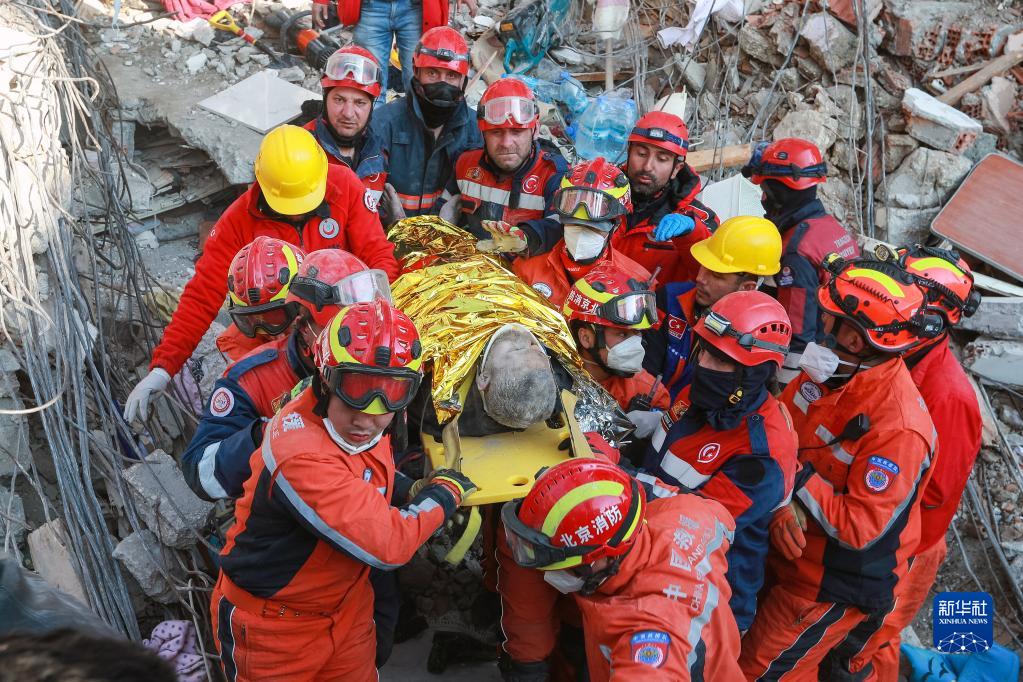 2023年2月12日，在土耳其哈塔伊省安塔基亞市，中土兩國救援隊隊員轉移一名救出的倖存者。