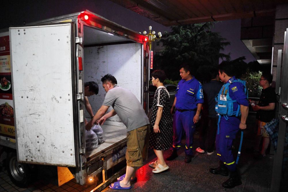 河北省涿州市職教中心安置點的工作人員在運送飯菜，準備發放給安置群眾（8月1日攝）。
