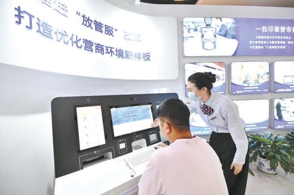 北京經開區政務服務中心自助服務機前，工作人員正在協助企業辦理“跨省通辦”業務。