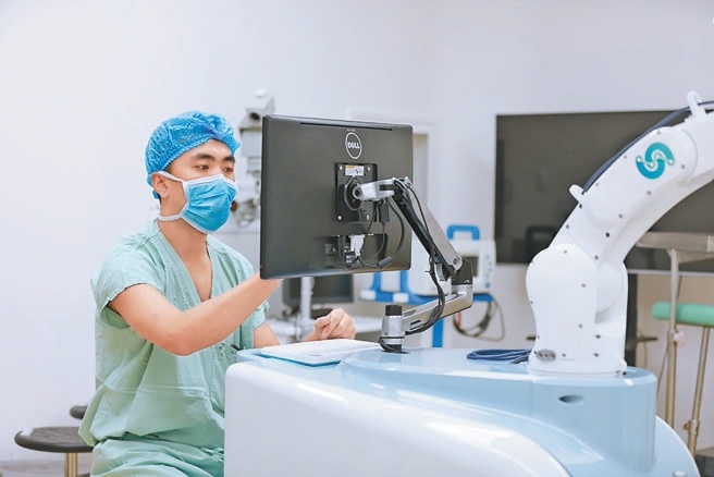 華科精準聯合創始人兼首席技術官劉文博正在調試手術機器人設備。