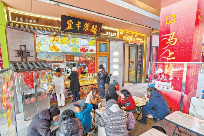 2月12日，在隆福寺豐年灌腸店舖，市民遊客品嘗北京特色小吃。