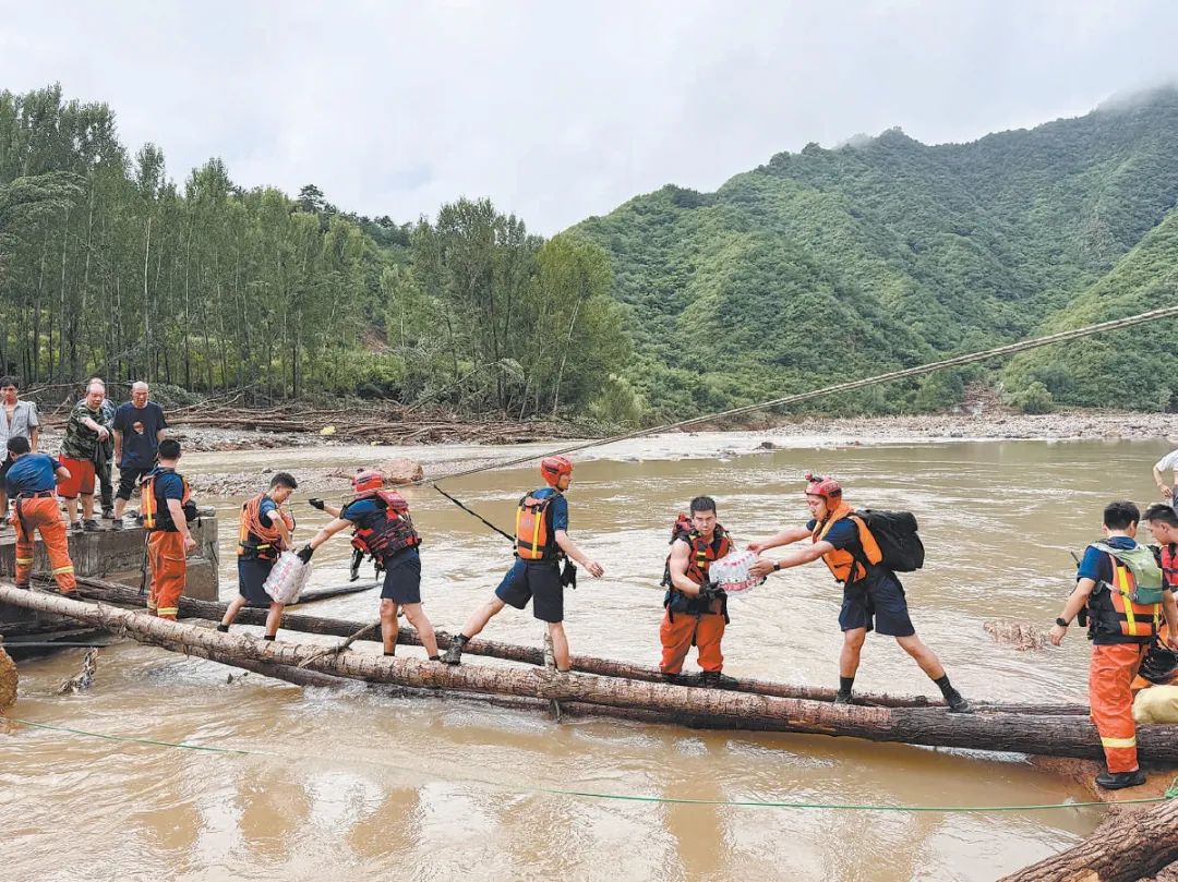 消防救援人員在簡易橋上轉移物資運往琉璃廟鎮碾子灣村。