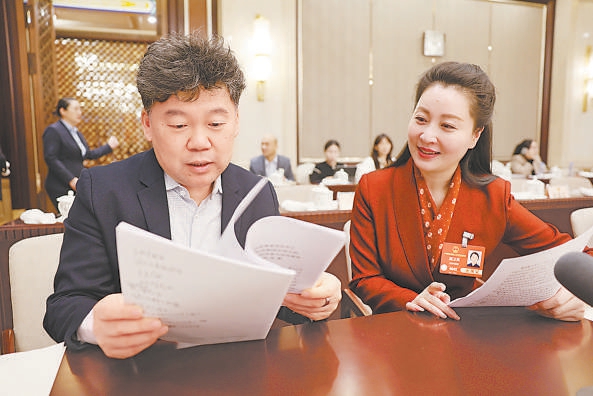 3月10日上午，十四屆全國人大三次會議北京市代表團召開全體會議，審議全國人大常委會工作報告和“兩高”工作報告。會議間隙，吳晨代表（左）和顧衛英代表繼續討論交流。
