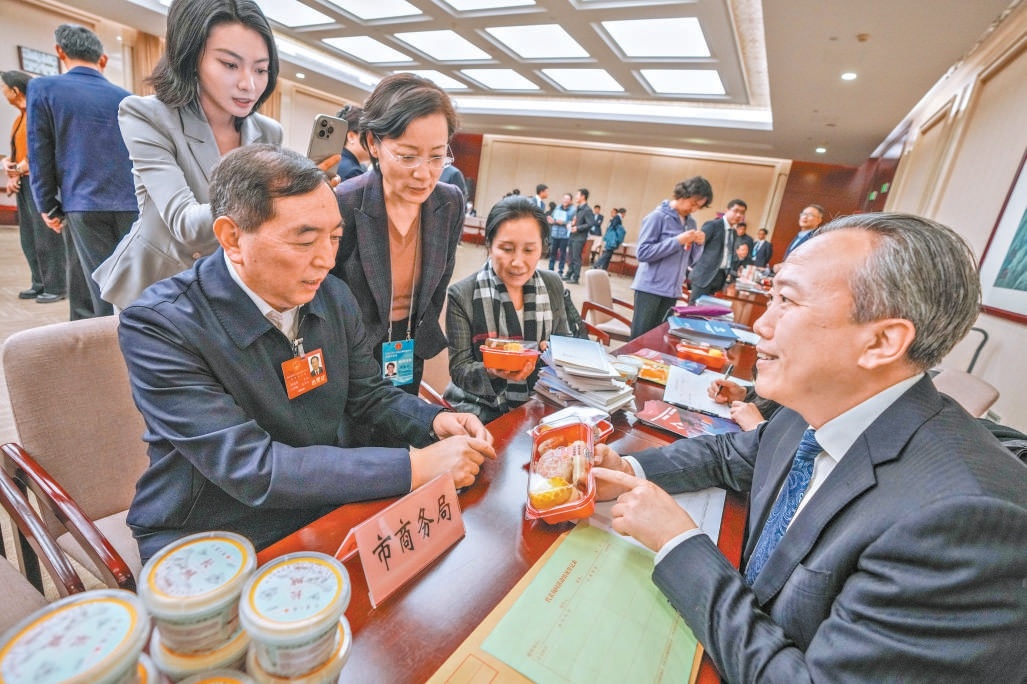 在市商務局諮詢臺，肖志剛代表（左）就北京老字號守正創新相關問題進行詢問。