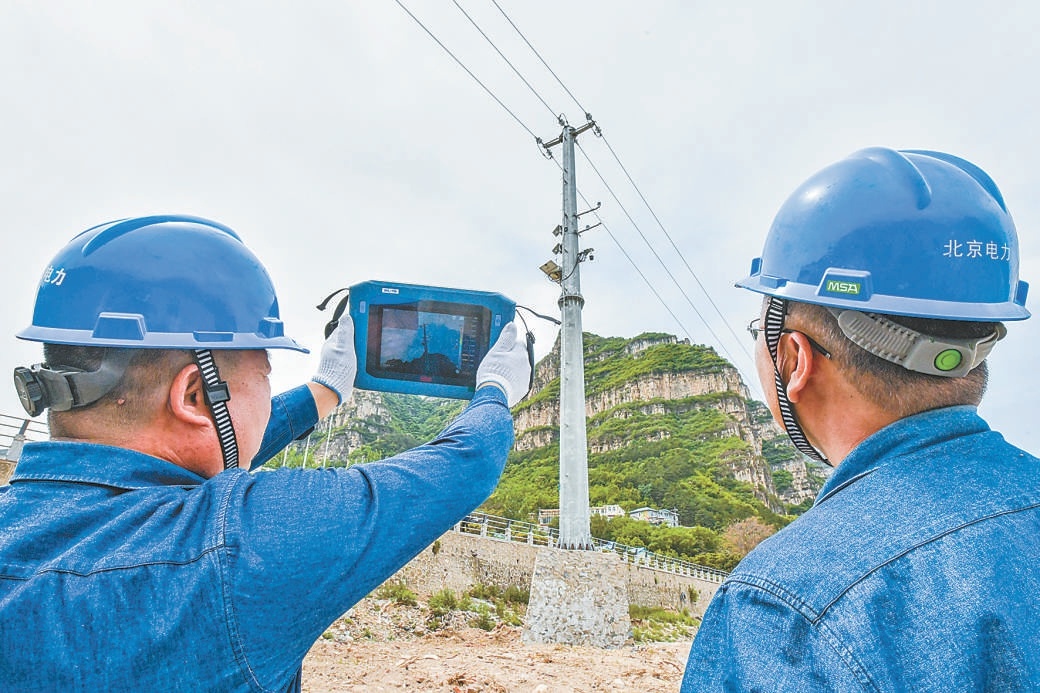 5月16日，在房山區十渡鎮，國網北京房山供電公司張坊供電所員工巡查災後恢復重建的10千伏西河路示範段線路，做好電力度汛保障。