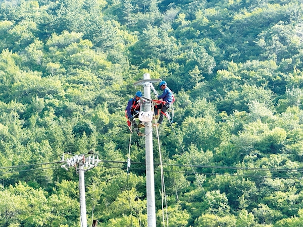 國網北京延慶供電公司應急支援團隊在門頭溝區清水鎮10千伏黃塔路組裝金具，為架線做好準備。