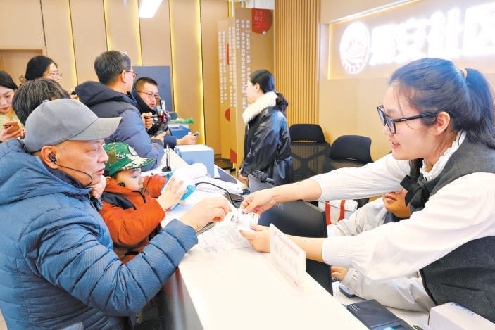 昨天，易安社區黨群服務中心工作人員在為社區居民辦理公交卡業務。