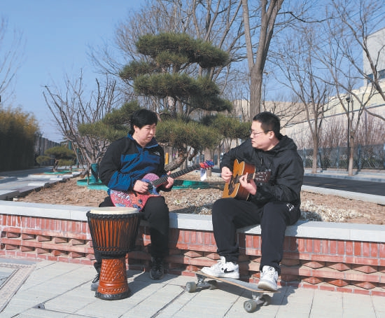 兩位音樂愛好者在臺湖舞美藝術中心口袋公園內彈奏樂器。