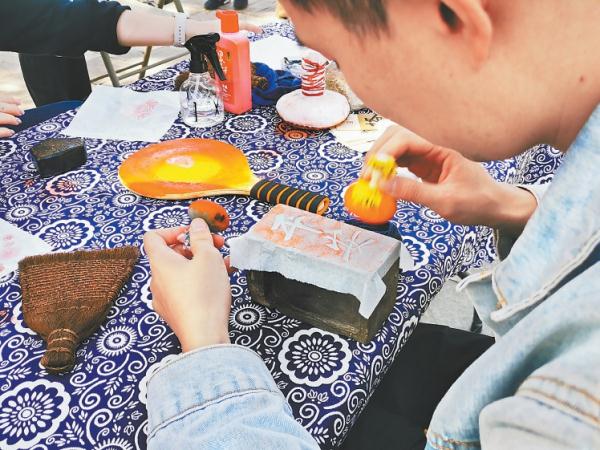 國慶期間，游客在八大處公園舉辦的活動中體驗非遺傳承技藝拓印。