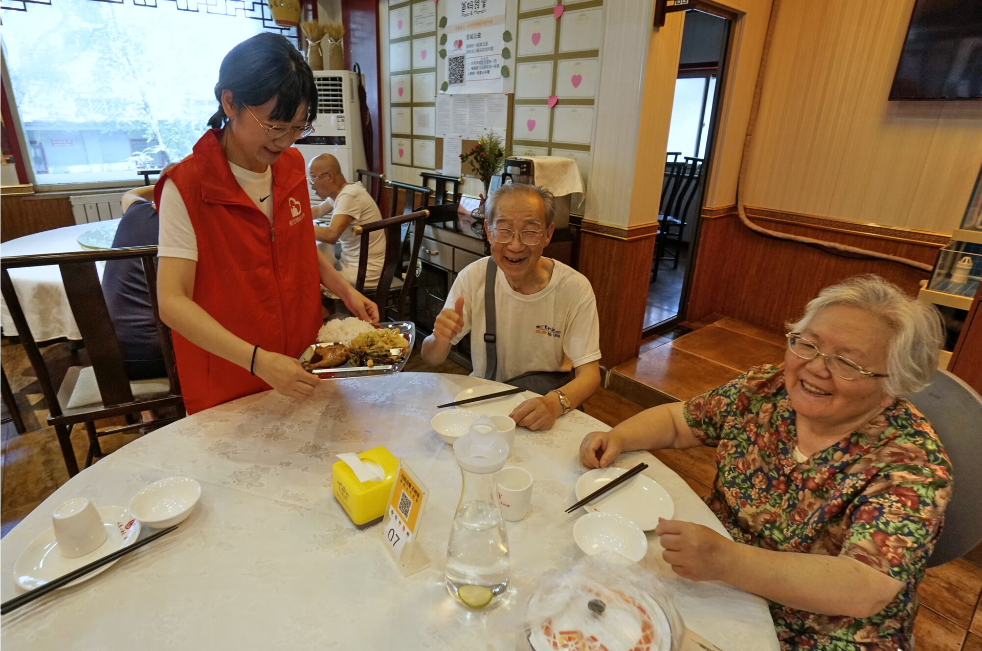 東城區東華門街道，一家“爸媽食堂”的員工為老人盛飯。