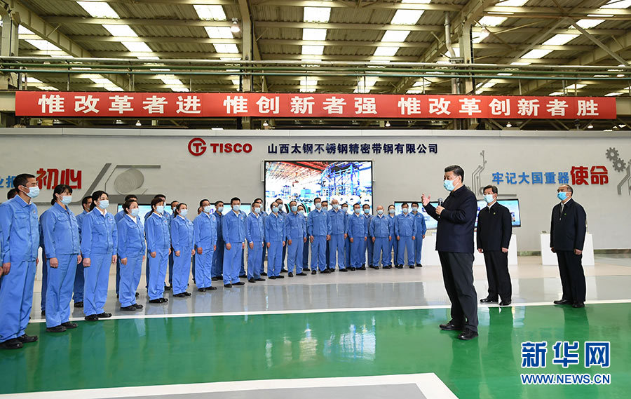 習近平在太鋼不銹鋼精密帶鋼有限公司生産車間考察時，同企業職工親切交流。