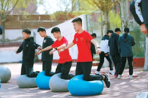 除了蹦床上的技巧练习，学生们还有平衡杆的训练和体能的锻炼。