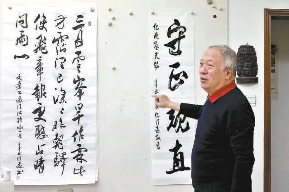 纪清远在画室书写并讲解纪晓岚留下来的尺铭“守正规直”。（白继开 摄）
