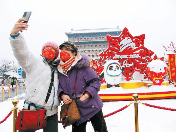 市民争相与街头的“冰墩墩”和“雪容融”合影。（杜建坡 摄）