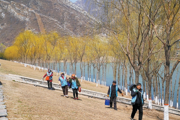 春天来了，管护员在永定河河堤坡地上铺设滴灌管线，准备浇“复青水”。不久，这里将呈现水清堤绿、百花盛开的美景。