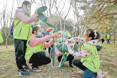 孩子们给小树穿冬衣，护绿爱绿。（何建勇 摄）