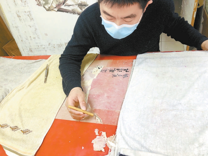 隋涛在修复古字画。