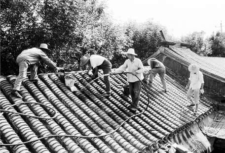 1984年雨季到来之前，朝阳门房管所维修二班的工人们为演乐胡同11号居民抢修屋面。