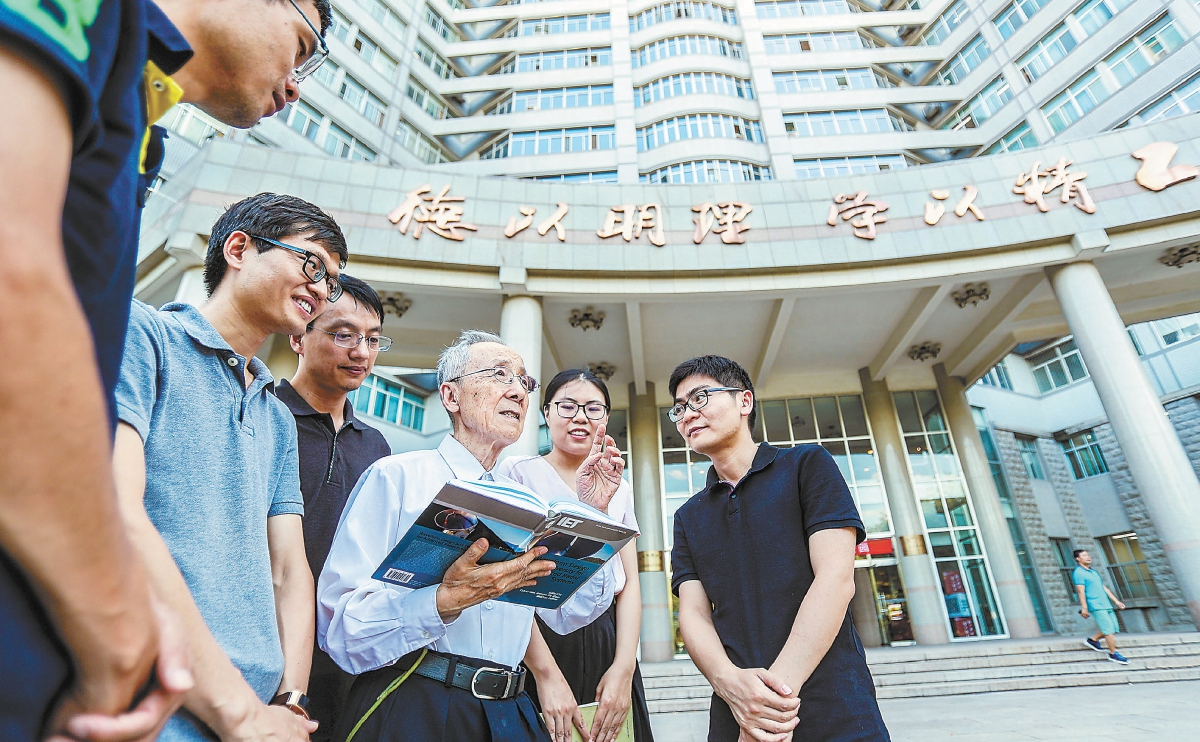 毛二可院士（中）在北京理工大学校园内与同事和学生交流。
