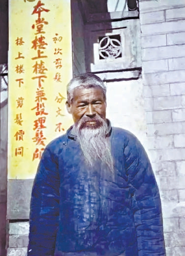 1920年代，站在理发馆前的老者。后面的招牌显示“初次剪发，分文不取”。