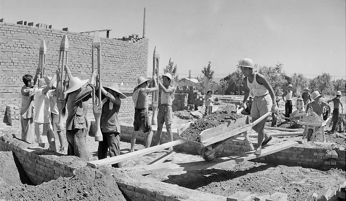 1958年，北京市土木建筑工程学校师生参加勤工俭学活动。图为他们在修建教学楼。