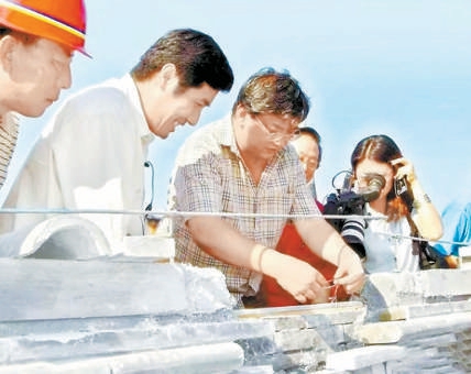 2004年8月18日，永定门城楼大脊最后一块瓦“合龙”。左一为马继友、左二为李彦成、左三为徐雄鹰。