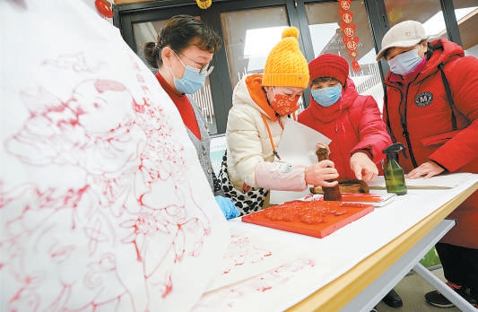2021年2月3日，在什刹海街道兴华社区，居民在民俗协会老师的指导下制作木版年画。