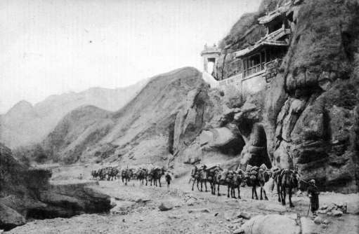 青龙桥村主街道是关沟古道的一部分。图为1898年正在关沟古道上行进的骆驼队。此处是八达岭关沟中著名的地段“五贵头”，庙宇是五贵头山上魁星阁，始建于元代。