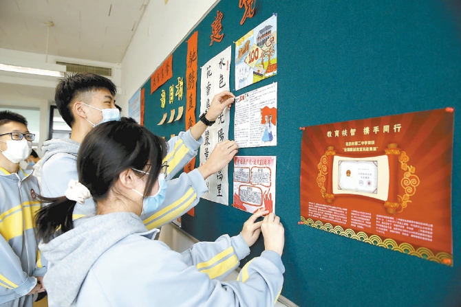 回到校园的高二3班学生在教室布置自己制作的以纪念建党100周年为主题