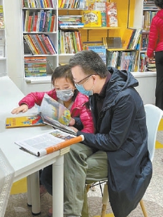 阅想书店里家长带着孩子读书。