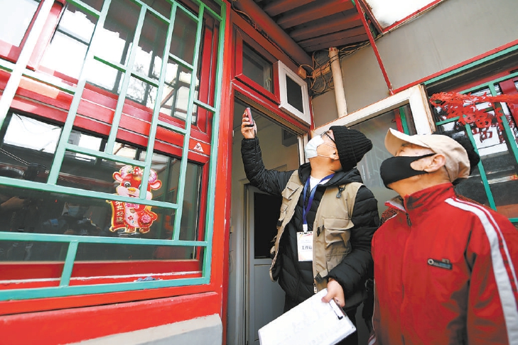 在项目启动首日就提出申请的三眼井胡同居民何大爷家里，工作人员对房屋进行测量复核。（和冠欣 摄）.jpg