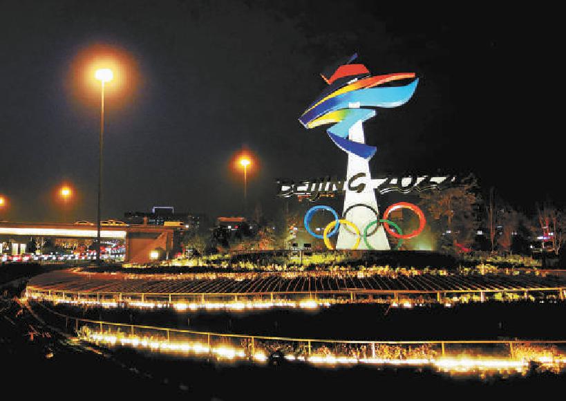 位于石景山区西五环晋元桥区域的北京冬奥会会徽雕塑在夜景照明的映衬下流光溢彩。（吴镝 摄）