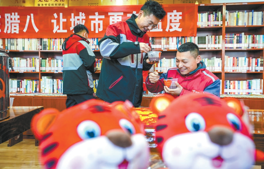 2022年1月9日，在顺义区胜利街道建北一社区暖心驿站，快递员品尝腊八粥，观看冬奥宣传片。（武亦彬 摄）.jpg