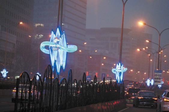 2022年1月23日，德胜门附近的涉冬奥道路，带有冬奥会标志的装饰灯与路灯同步开启，营造浓浓的冬奥氛围。（程功 摄）