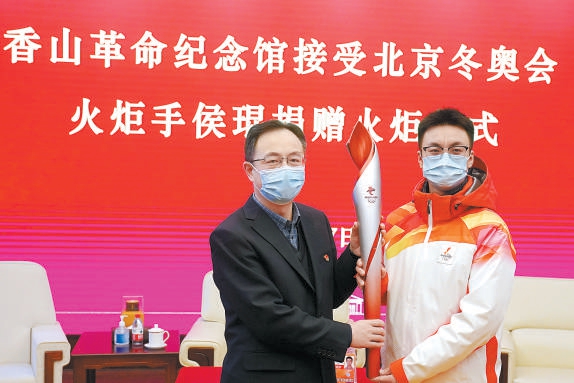 2022年2月7日，北京冬奥会火炬手侯琨（右）将其传递过的北京冬奥会火炬捐赠给香山革命纪念馆。（王海欣摄）