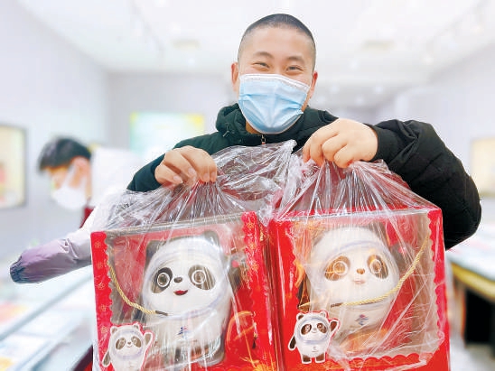 2022年2月14日，在位于王府井工美大厦的北京2022官方特许商品旗舰店，提前预订的消费者领到了冰墩墩毛绒玩具。（阎彤 摄）