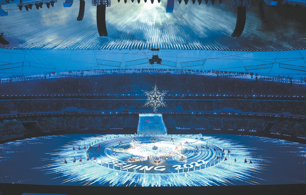 冬残奥会主火炬熄灭环节，“BEIJING 2022”的字样烙印在唱片上。璀璨的星辰中，浮现出雪花绽放的倒影，与夜空中的雪花主火炬台遥相辉映。（武亦彬 摄）