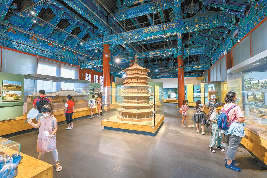 北京古代建筑博物馆暑假迎来了青少年参观高峰。孩子们在老师的指导下仔细观察古建模型，并不时将所看所获记录下来。