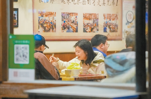 周末，在簋街一家餐厅内，选择堂食的市民愉快享用美食。