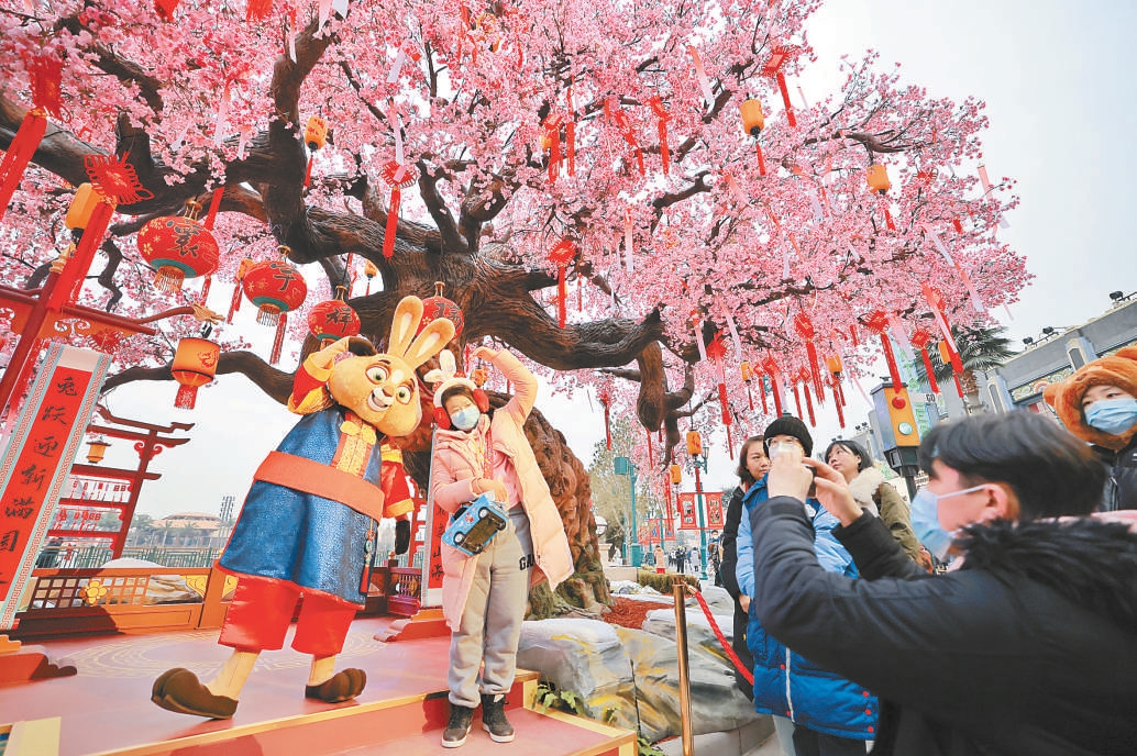 1月12日，游客在环球新春许愿树下与伍哈兔合影留念。