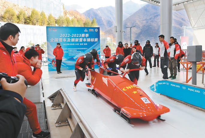 四人雪车国家队运动员在比赛中奋力出发。