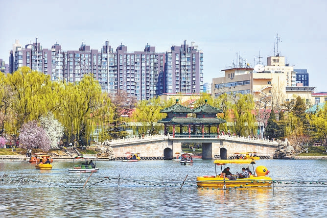 3月28日，市民在龙潭公园泛舟赏景。