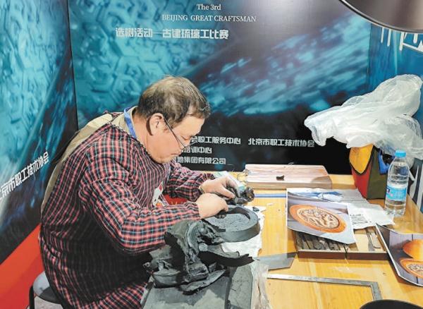 比赛现场，选手专心致志对着图片复制故宫瓦当。