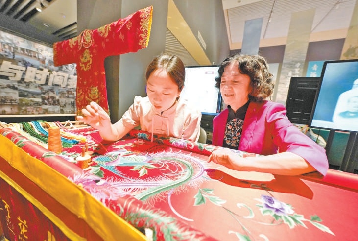 图为展览现场举办的京绣技艺展示。