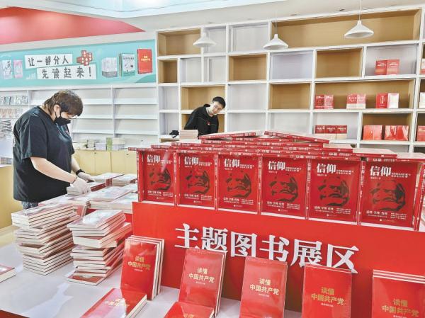 北京联合出版公司展区工作人员正在摆放图书。