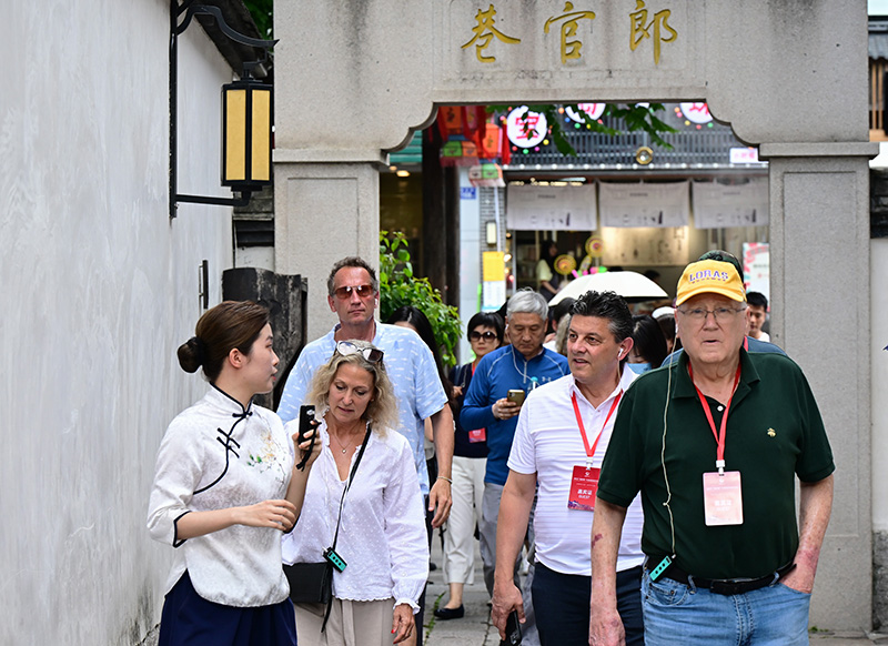 “鼓岭之友”部分成员和中美各界人士在福州南后街三坊七巷参观访问（2023年6月27日摄）。