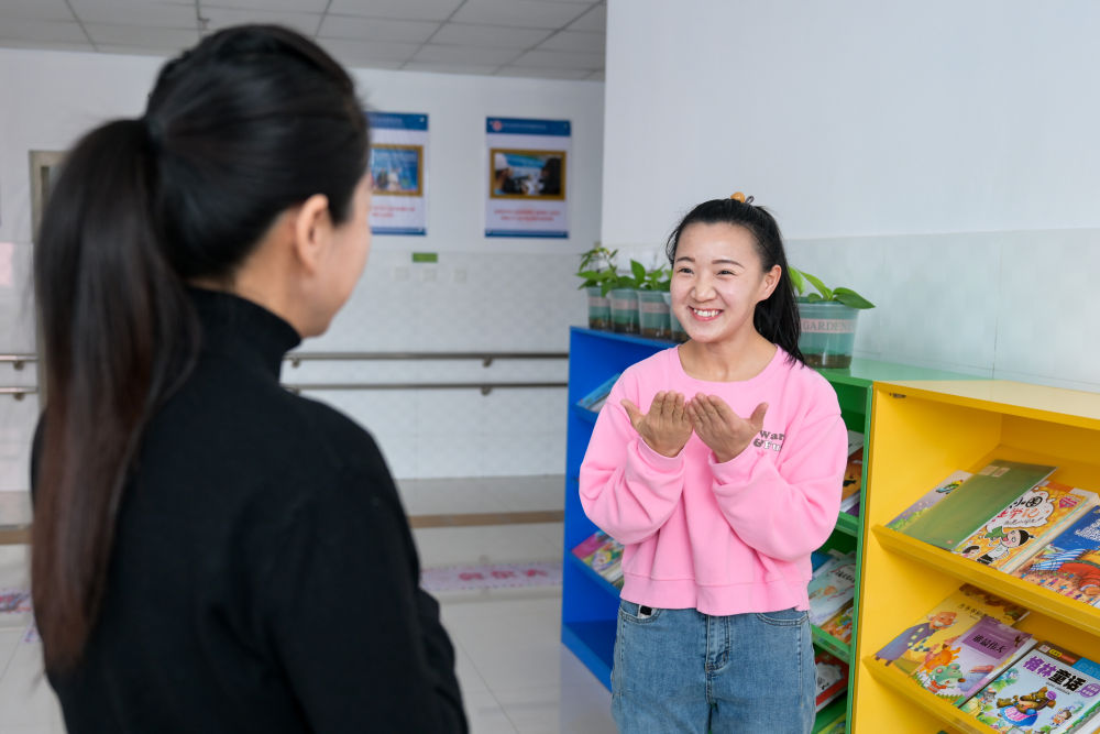 王雅妮（右）在内蒙古呼和浩特市特殊教育学校与同事交流（2024年2月4日摄）。