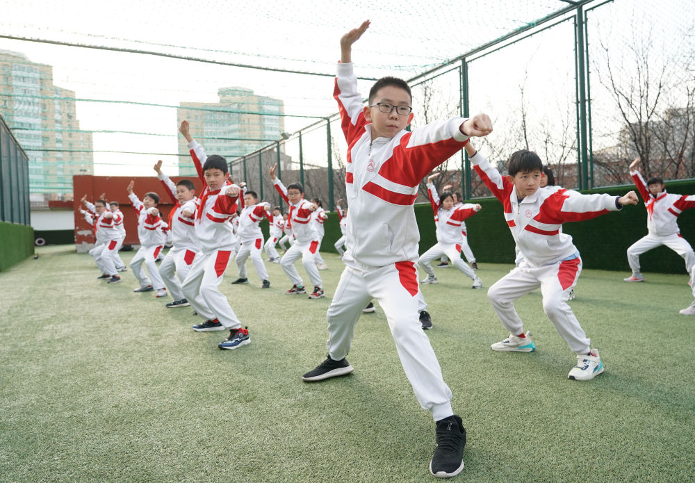 2024年2月21日，在人大附中实验小学，学生们在体育课中进行武术练习。