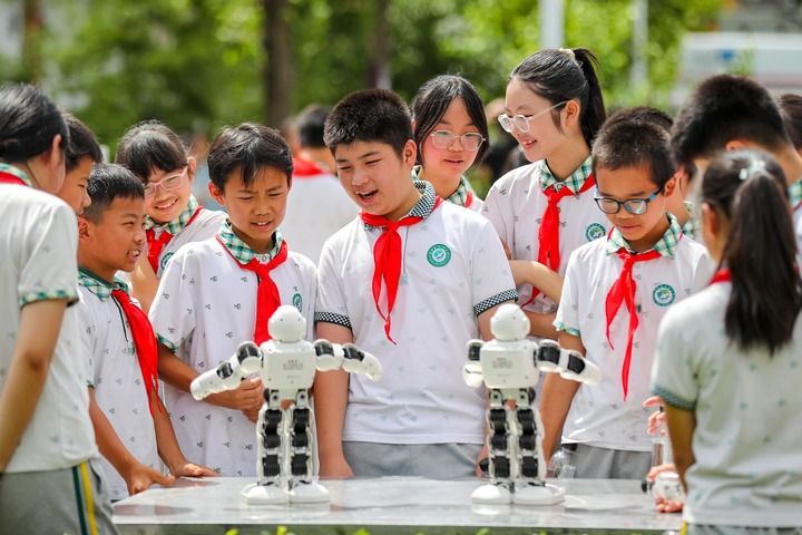 2024年5月30日，四川省宜宾市长宁县希望小学的学生们在迎“六一”活动上观看机器人舞蹈表演。